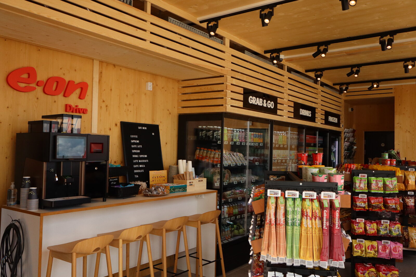 The counter inside the lounge with coffee machine, chillers and light timber shelving